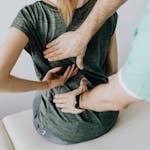 A chiropractor examining a patient's back to alleviate pain and discomfort.
