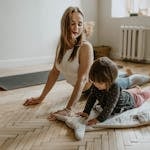 A mother and child practicing yoga together at home on a sunny day, fostering wellness and connection.
